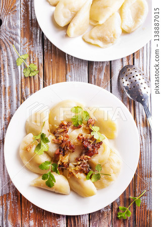 Dumplings with fried onions on white plate. Varenyky, vareniki, pierogi. 138887015