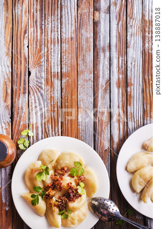 Dumplings with fried onions on white plate. Varenyky, vareniki, pierogi. 138887018