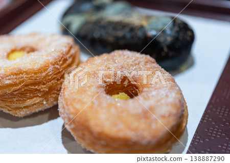 Closeup of sugar coated donut pastry with crispy layers and soft center served on plate showing sweet texture and bakery freshness with shallow depth of field Closeup of sugar coated donut pastry with crispy layers and soft center served on plate showing sweet texture and bakery freshness with shallow depth of field 138887290