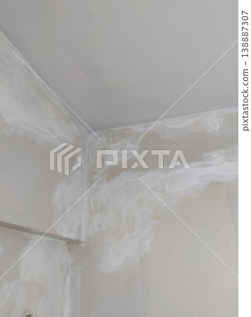 Damaged ceiling corner with plaster patches and damp stains Damaged ceiling corner with plaster patches and damp stains 138887307