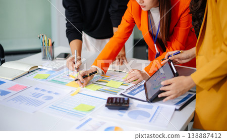 Business People Talking Discussing with financial document data charts and graphs Team business meeting with smart phone and laptop and digital tablet computer 138887412
