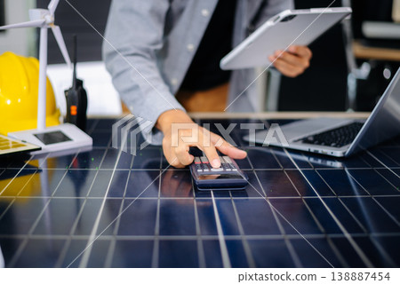 Engineer pointing on solar panel table with tablet and wind model, symbolizing clean energy, innovation, and smart technology for future sustainable development. Engineer pointing on solar panel table with tablet and wind model, symbolizing clean energy, innovation, and smart technology for future sustainable development. 138887454