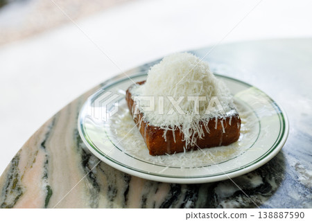 Fresh bread butter toast with Vanilla flavor ice cream topped with grated Parmesan cheese on white ceramic plate on marble table. 138887590
