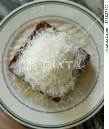 Fresh bread butter toast with Vanilla flavor ice cream topped with grated Parmesan cheese on white ceramic plate on marble table. Fresh bread butter toast with Vanilla flavor ice cream topped with grated Parmesan cheese on white ceramic plate on marble table. 138887592
