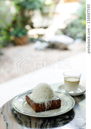 Fresh bread butter toast with Vanilla flavor ice cream topped with grated Parmesan cheese on white ceramic plate on marble table. Fresh bread butter toast with Vanilla flavor ice cream topped with grated Parmesan cheese on white ceramic plate on marble table. 138887593