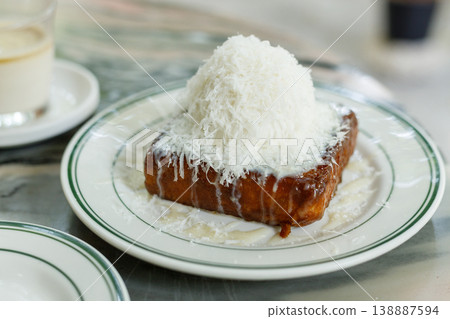 Fresh bread butter toast with Vanilla flavor ice cream topped with grated Parmesan cheese on white ceramic plate on marble table. Fresh bread butter toast with Vanilla flavor ice cream topped with grated Parmesan cheese on white ceramic plate on marble table. 138887594