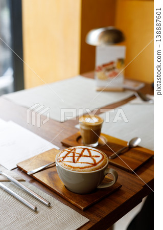 Cup of hot milk caramel macchiato coffee and piccolo latte coffee  on table by the window. 138887601