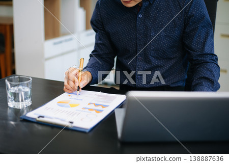man multitasking with smartphone and laptop in bright modern office. Ideal for business, remote work, productivity, and digital communication lifestyle themes. 138887636