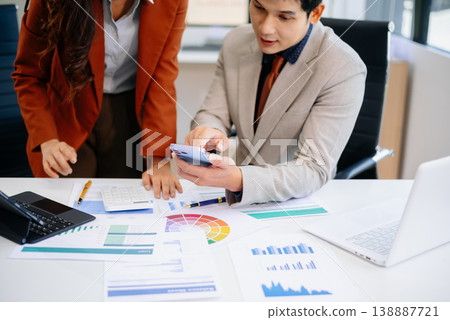 Two professionals working together using tablet and printed reports in a modern office. Perfect for teamwork, strategy, financial planning Two professionals working together using tablet and printed reports in a modern office. Perfect for teamwork, strategy, financial planning 138887721