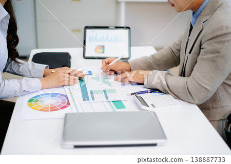 Two professionals reviewing business charts and data with tablet and documents. Ideal for financial planning, corporate teamwork, and modern office Two professionals reviewing business charts and data with tablet and documents. Ideal for financial planning, corporate teamwork, and modern office 138887733