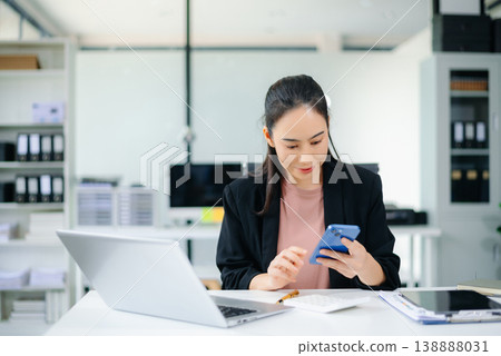 Confident Asian businesswoman using tablet in modern office with laptop and documents, showcasing finance, remote work Confident Asian businesswoman using tablet in modern office with laptop and documents, showcasing finance, remote work 138888031