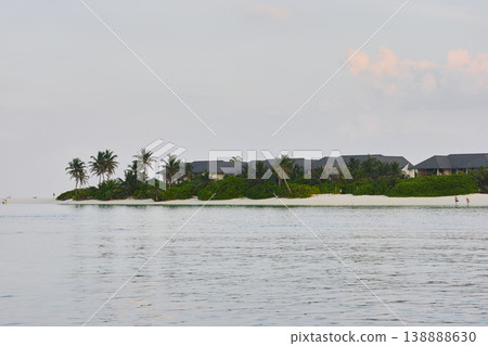 Classic Maldives island landscape on a sunset, azure water, white sand, palm trees on the shore Classic Maldives island landscape on a sunset, azure water, white sand, palm trees on the shore 138888630