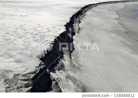 A sand cliff formed when the beach is eroded at low tide. A sand cliff formed when the beach is eroded at low tide. 138888812