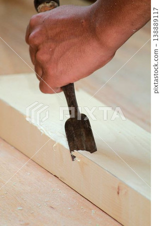 A scene of traditional handiwork, where wood is precisely carved using woodworking techniques. A scene of traditional handiwork, where wood is precisely carved using woodworking techniques. 138889117