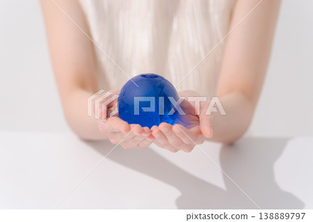 一隻女人的手拿著一個球形物體 138889797