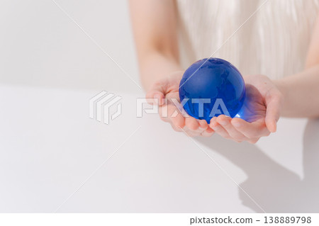 一隻女人的手拿著一個球形物體 138889798