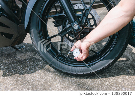 Checking the air pressure of motorcycle tires 138890017