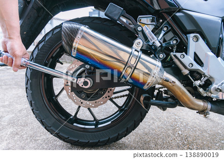 Tighten the rear axle nut on the motorcycle with a torque wrench. Tighten the rear axle nut on the motorcycle with a torque wrench. 138890019