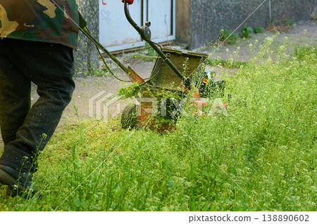 Handle lawn mower,grass cutting on green meadow 138890602
