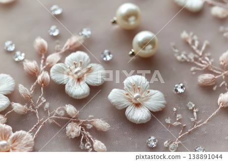 This close-up shows lace embroidery with floral patterns on a white wedding dress. Pearls and beads sit alongside intricate stitching, highlighting the fine craftsmanship This close-up shows lace embroidery with floral patterns on a white wedding dress. Pearls and beads sit alongside intricate stitching, highlighting the fine craftsmanship 138891044