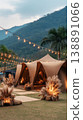 A wedding tent is set up in a grassy space with trees around. Inside, there are cushions and lights creating a cozy atmosphere for guests to relax and enjoy 138891066