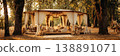 A wedding tent is set up in a grassy space with trees around. Inside, there are cushions and lights creating a cozy atmosphere for guests to relax and enjoy 138891071