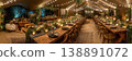 An outdoor wedding tent showcases macrame details and soft floral arrangements. Tables are set for guests with candles, bringing a warm glow as evening approaches at the venue 138891072