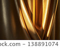 Shiny yellow curtains with soft folds create rich texture and visual interest. They hang in a well-lit space, reflecting light beautifully throughout the area 138891074