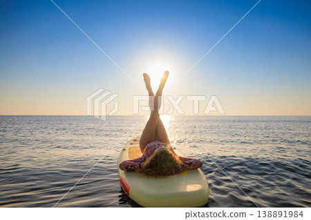 Young woman walking on sup board by the sea during summer vacation 138891984