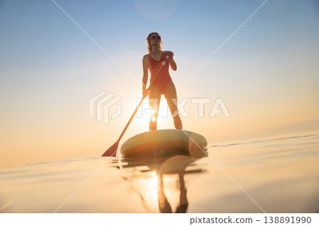 Young woman walking on sup board by the sea during summer vacation 138891990