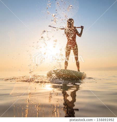 Silhouette woman walking on sup board by the sea during summer vacation 138891992