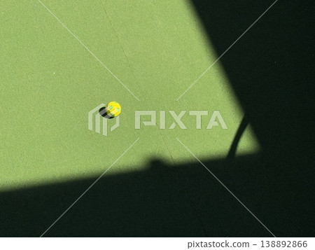Yellow soccer ball on green field cornered by shadow creates strong contrast and unique background 138892866