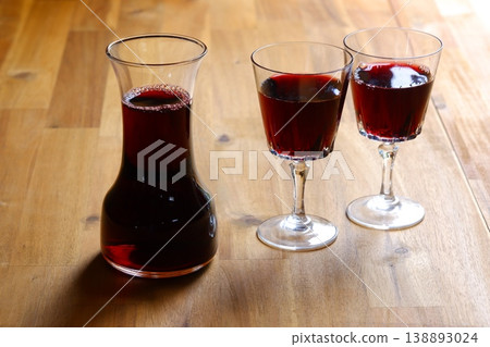 Toasting with red wine - Image of two wine glasses filled with red wine making a toast Toasting with red wine - Image of two wine glasses filled with red wine making a toast 138893024