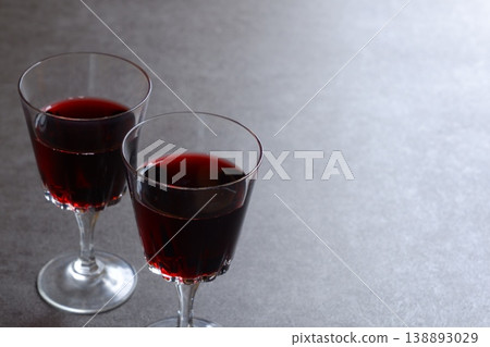 Toasting with red wine - Image of two wine glasses filled with red wine making a toast Toasting with red wine - Image of two wine glasses filled with red wine making a toast 138893029