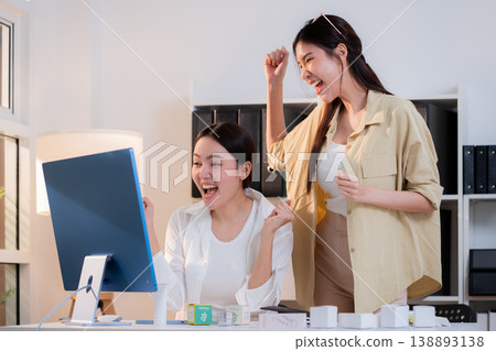 Two asian businesswoman team celebrate success with excited for cosmetic packaging design. Two asian businesswoman team celebrate success with excited for cosmetic packaging design. 138893138