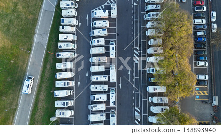Large outdoor RV parking lot in Cremona, Italy seen from above, rows of motorhomes and camper vans amid urban autumn surroundings 138893940