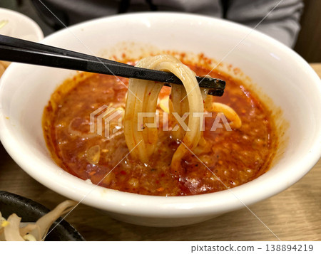 Spicy Tsukemen (Dipping Noodles) - A close-up of dipping noodles into a super spicy red soup. Spicy Tsukemen (Dipping Noodles) - A close-up of dipping noodles into a super spicy red soup. 138894219