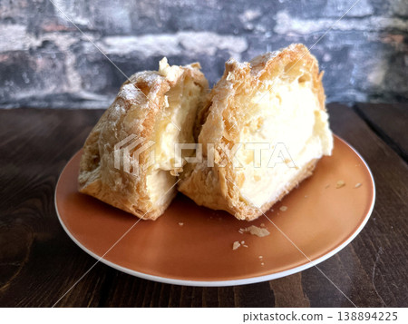 Cross-section of a pastry-crusted cream puff - a different angle of the custard cream. Cross-section of a pastry-crusted cream puff - a different angle of the custard cream. 138894225