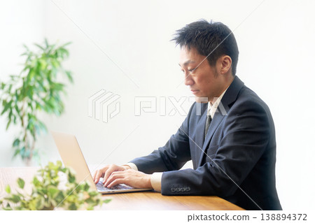 Office worker concentrating on computer operations at their desk Office worker concentrating on computer operations at their desk 138894372
