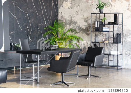 Modern loft office interior with black desk, leather chairs and industrial library shelving 138894820