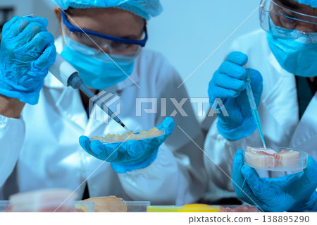 Team Food Safety Scientists Testing Meat Samples in Laboratory for Contamination and Chemical Residue Analysis. 138895290