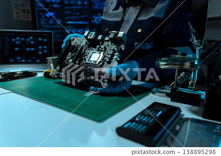 Computer Hardware Technician Repairing Motherboard with Soldering Iron in Electronics Lab. 138895298