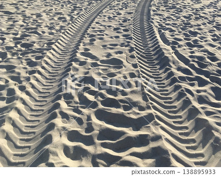 Tire tracks and footprints leading to the white sandy beach 138895933