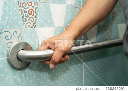 Asian woman patient use handrail safety in toilet support rail in bathroom. 138896001