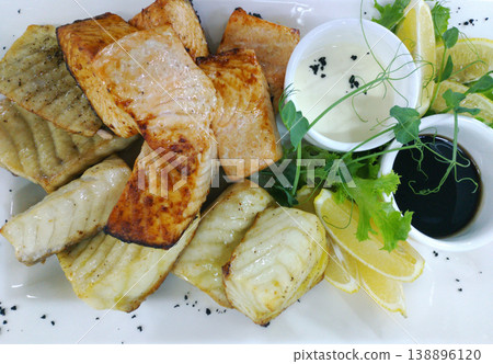 Fried sturgeon and salmon fillets with lemon slices, cherry tomatoes Fried sturgeon and salmon fillets with lemon slices, cherry tomatoes 138896120