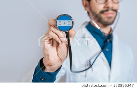 Doctor holding stethoscope with Honduras flag. Honduras health and care concept, Honduras flag on stethoscope Doctor holding stethoscope with Honduras flag. Honduras health and care concept, Honduras flag on stethoscope 138896347