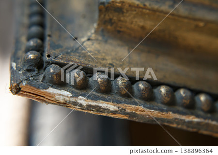 Close View of an Old Wooden Frame With Metal Detailing Showing Wear and Age From Years of Use in a Historical Setting Close View of an Old Wooden Frame With Metal Detailing Showing Wear and Age From Years of Use in a Historical Setting 138896364