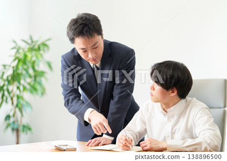 一位年輕男子正在接受老師的一對一指導。 138896500