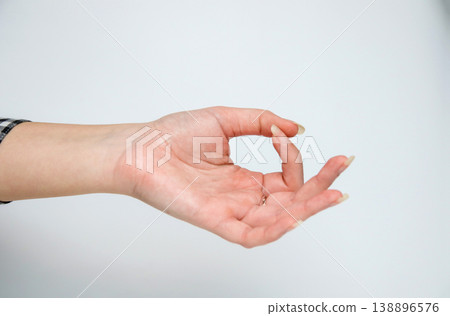 Close-up of a female hand in a mudra gesture isolated on a white background. Concept of meditation, yoga, mindfulness, and inner peace. Minimalist spiritual practice Close-up of a female hand in a mudra gesture isolated on a white background. Concept of meditation, yoga, mindfulness, and inner peace. Minimalist spiritual practice 138896576