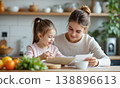 Mother daughter kitchen reading nutritional guidelines together at home while smiling in a bright modern kitchen environment 138896613